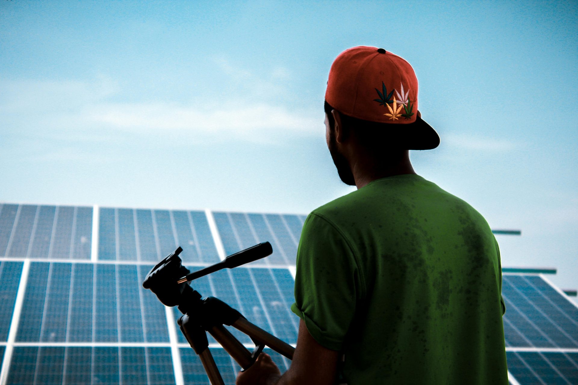 Una persona con gorra filma una instalación de paneles solares, promoviendo soluciones energéticas sustentables.