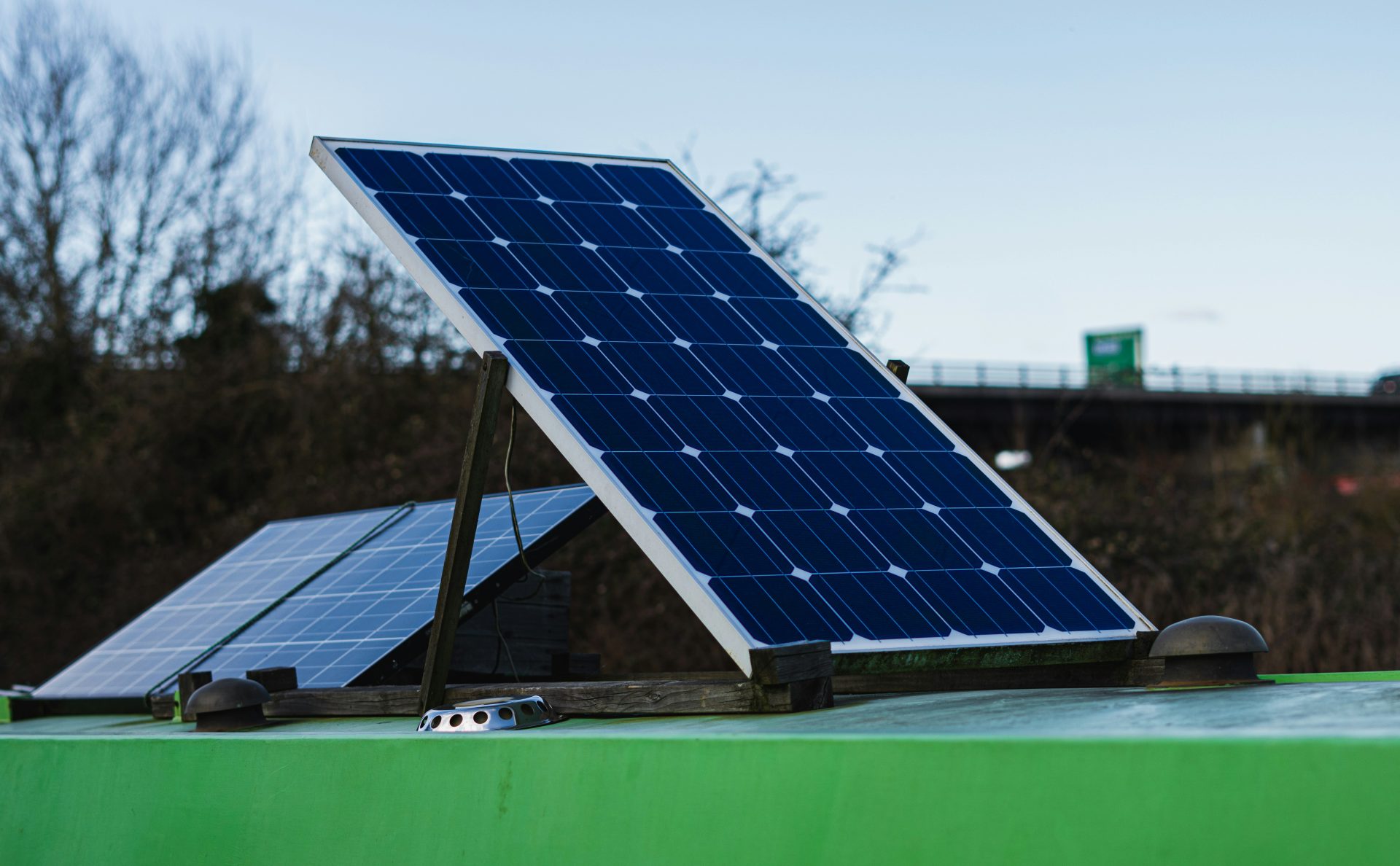 Panel solar azul y blanco sobre una barra de metal verde durante el día.