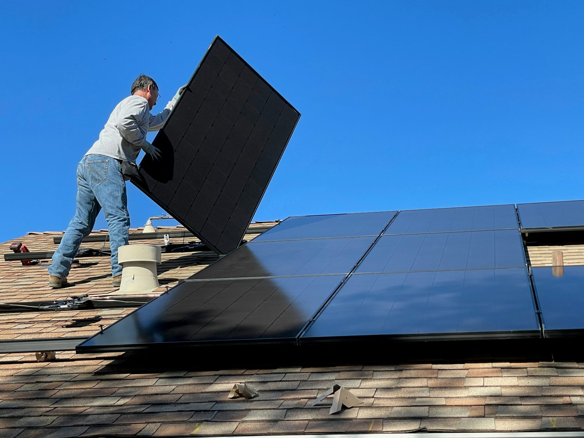 Hombre en un tejado instalando paneles solares
